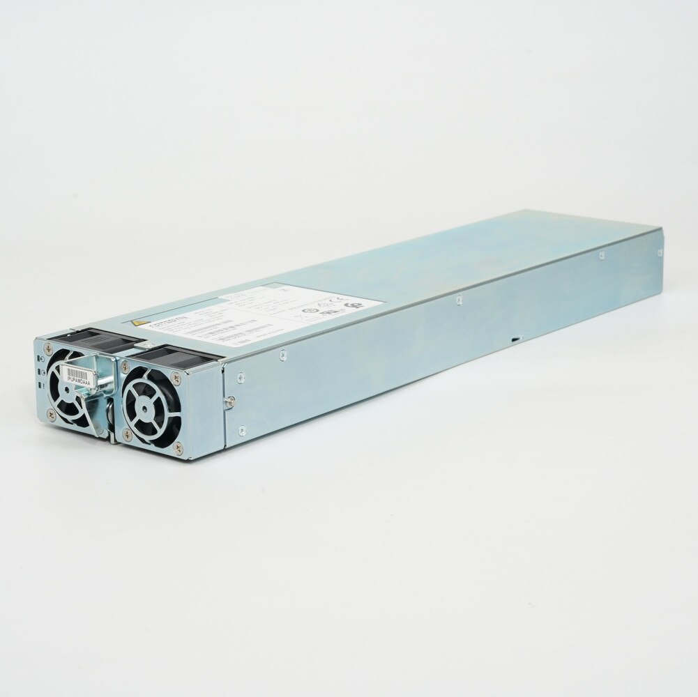 A Cisco ASR 9000 Series Power Supply PWR-2KW-DC-V2. It is a silver rectangular device with a fan and a power cord. It is used to provide power to the Cisco ASR 9000 Series routers.